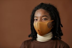 Stylish portrait of a woman wearing a brown face mask, showcasing change in lifestyle.