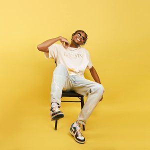 Young man posing with confidence in a vibrant fashion studio setting.