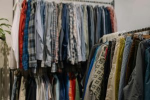 Assorted clothing on racks in a thrift shop, showcasing various styles and colors.